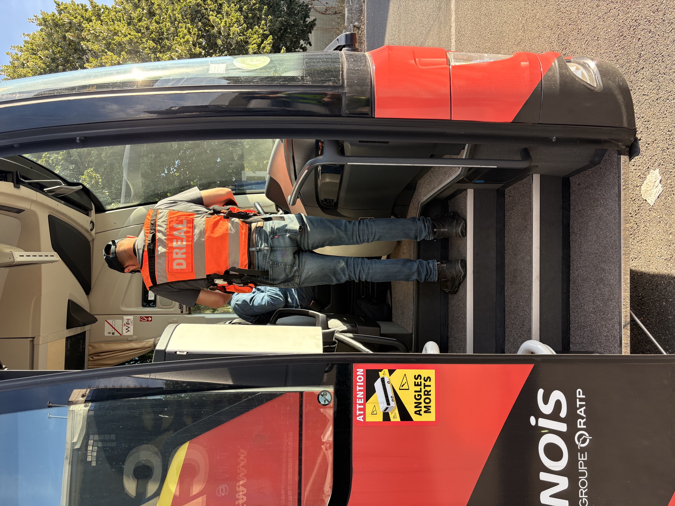 La photo représente un contrôleur des transports à bord d'un autocar durant un contrôle routier